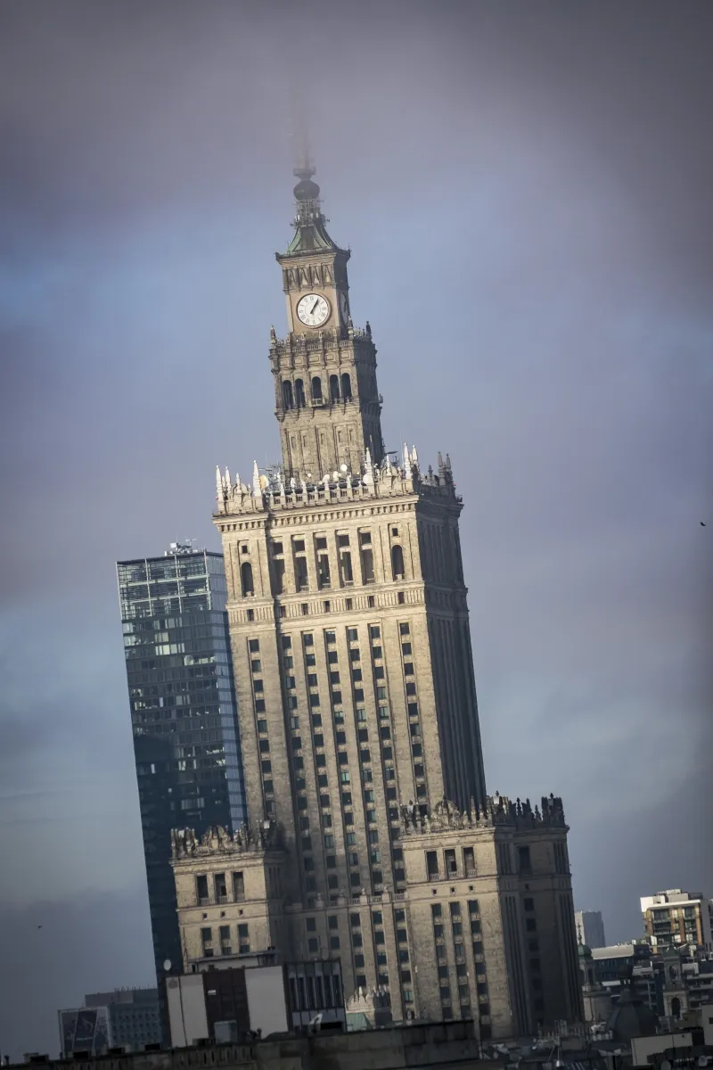 Palace of Culture and Science clock tower rising above Warsaw under a stormy sky
